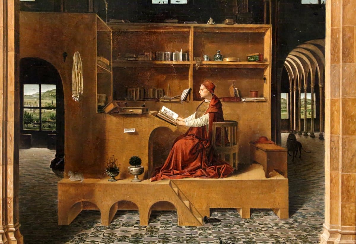 Antonello da Messina, Saint Jerome in His Study: Jerome reading a large book at a raised wooden desk, his lion walking in the hall behind.